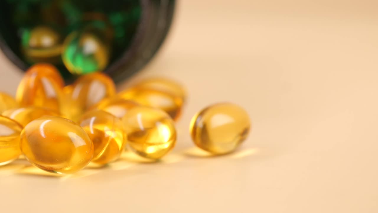 Yellow Gel Capsules Spilling from a Medicine Bottle