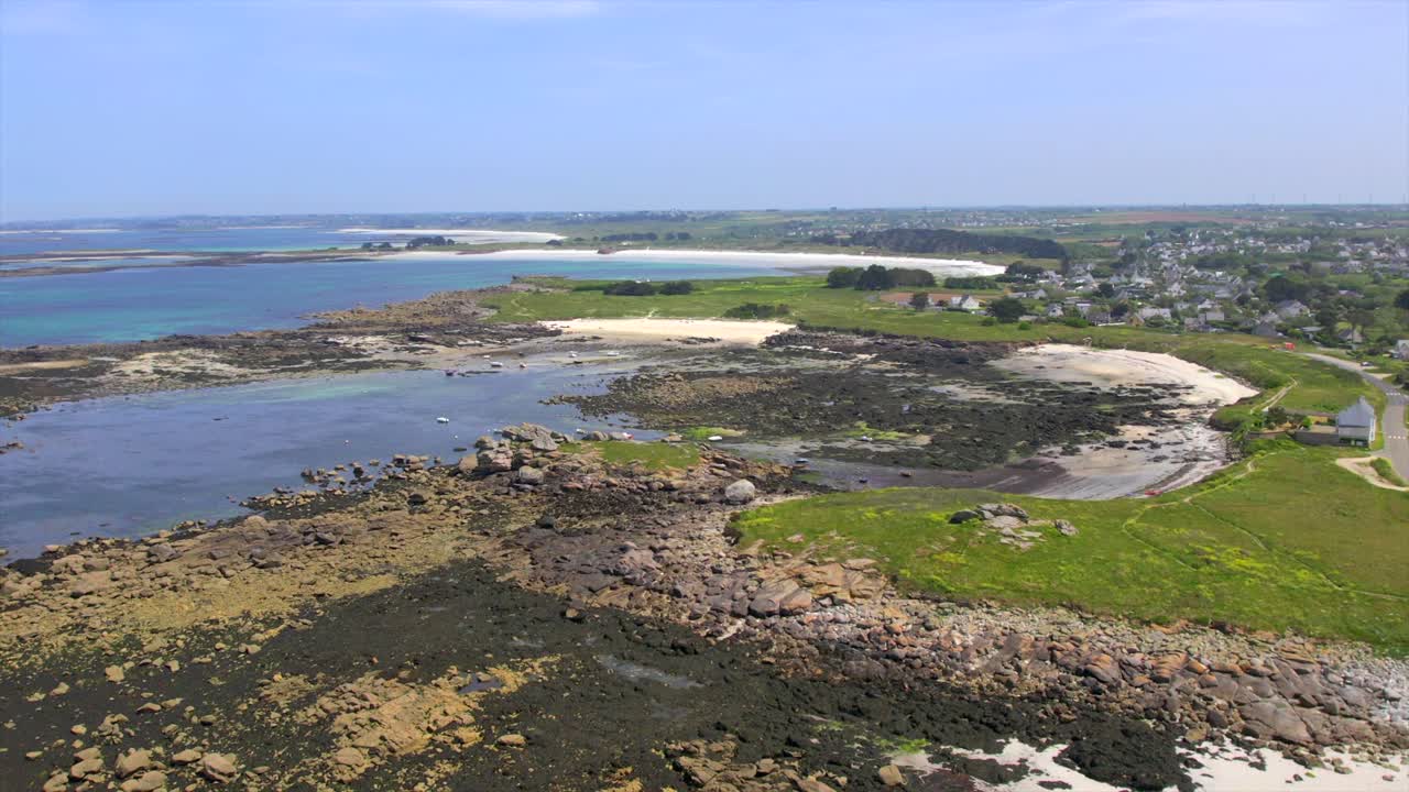 Brittany’s coastal landscape near Brest, showcasing rocky shores, sandy inlets, and lush green fields. This scene captures the unique, rugged charm of France’s Atlantic coastline. Drone aerial.
