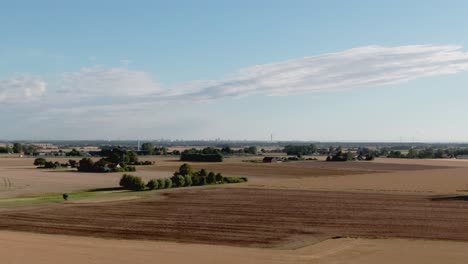 Aerial-rise-showing-vast-Swedish-landscape-and-city-Malmo-from-afar