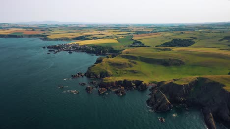 Vista-Aérea-De-La-Costa-De-Gran-Bretaña:-Los-Acantilados-De-Escocia-Y-El-Pequeño-Pueblo-Pesquero-De-St-Abbs.