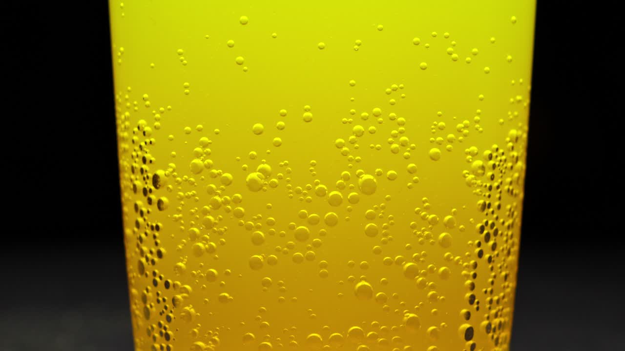 거품이 있는 차가운 오렌지 주스 한 잔의 클로즈업