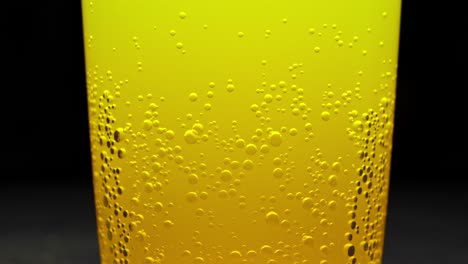 closeup of glass of fizzy cold orange juice with bubbles