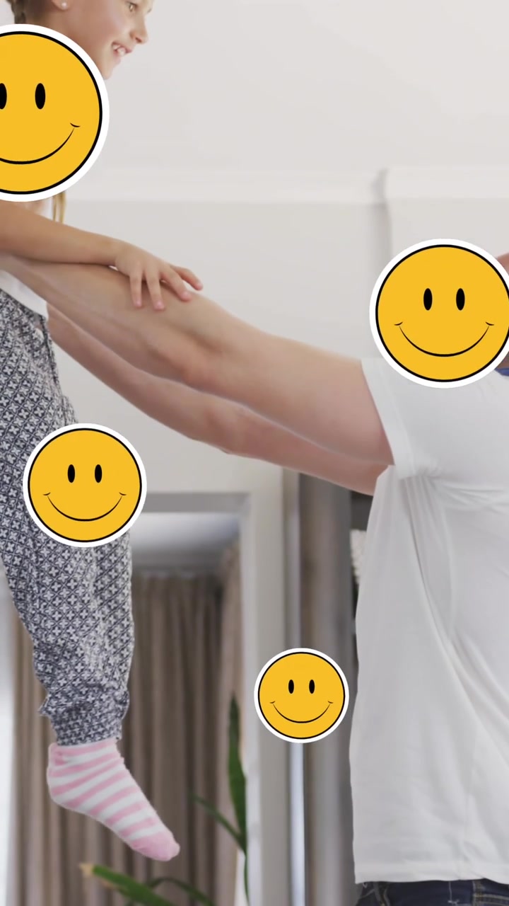 Animación de caras sonrientes sobre un padre y una hija caucásicos felices saltando en casa
