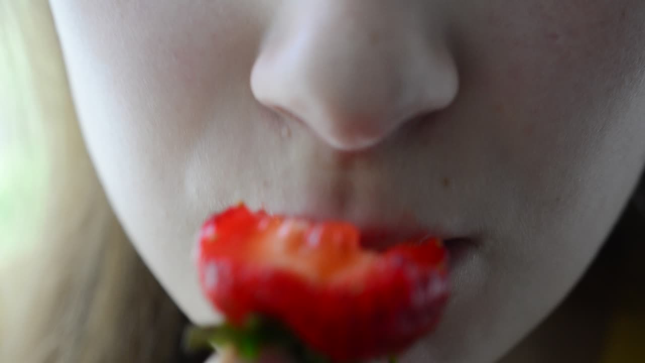 The girl eats strawberry