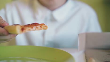 Kind-Isst-Abendessen-Mit-Leckerer-Pizza-Am-Tisch-Im-Zimmer,-Blick-In-Die-Nähe