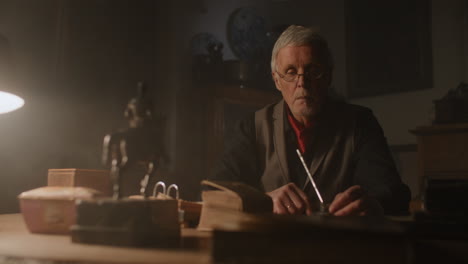 old passionate man look to the old book in his office at night