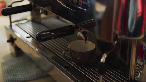 sección media de un barista afroamericano haciendo café en una máquina de café