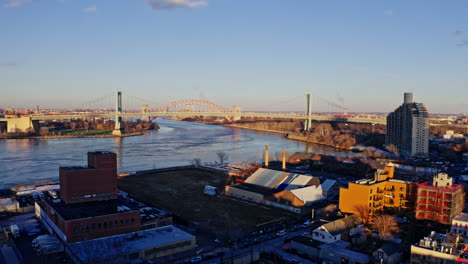 east river amidst buildings in city, drone flying backward from skyline