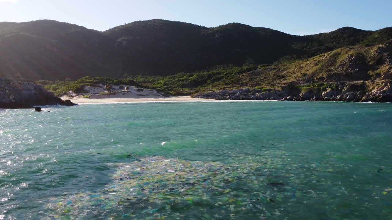 tembakan statis sampah yang mengapung di laut, pantai yang indah di latar belakang, vietnam