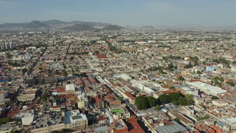 Vista-Aérea-Del-Barrio-De-La-Ciudad-De-México-Durante-El-Día,-Dolly-Back-Pan-Up