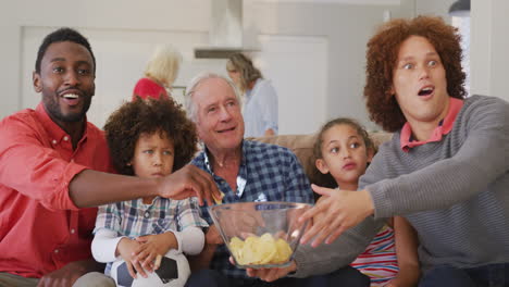 Video-of-diverse-family-siting-on-the-couch-and-watching-football-match