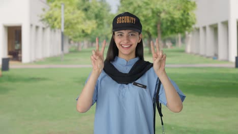 happy indian female security guard showing victory sign