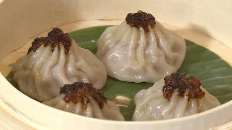 steamed soup dumplings in a bamboo steamer
