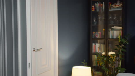 happy young woman with earphones and tablet entering living room and sitting on couch 1