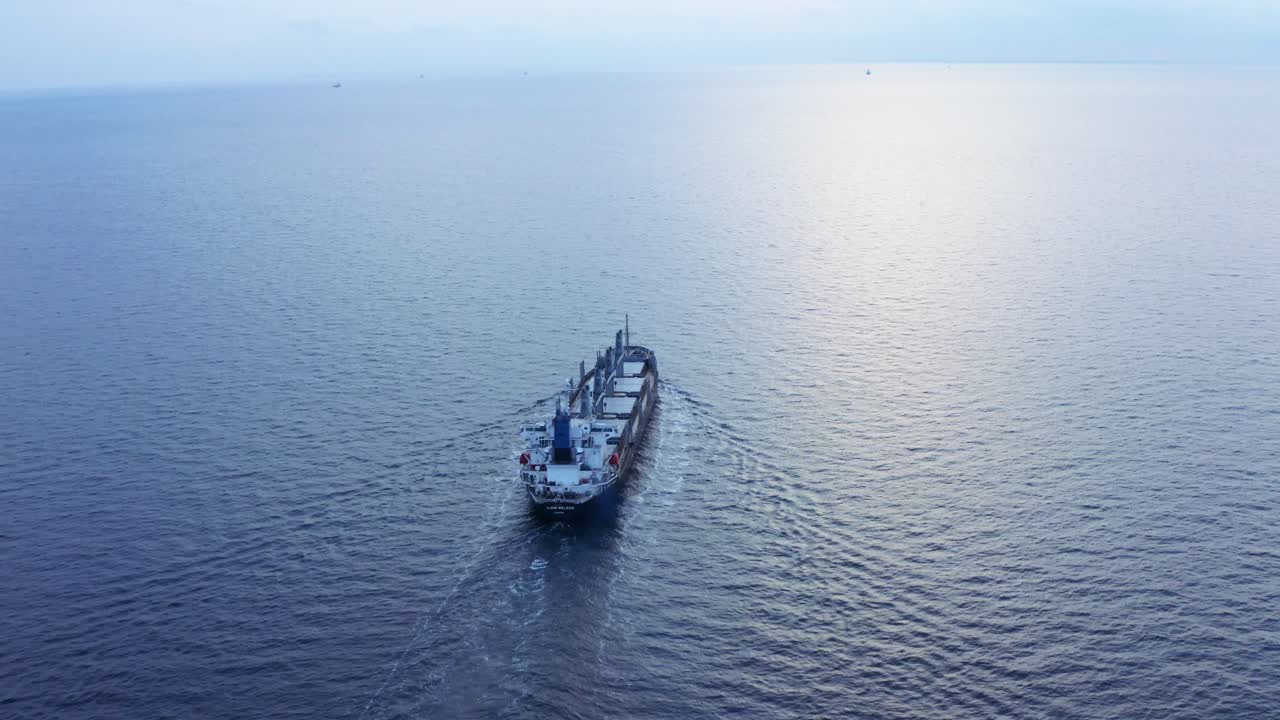 toma épica cinematográfica de un barco navegando en el mar hacia el horizonte del atardecer