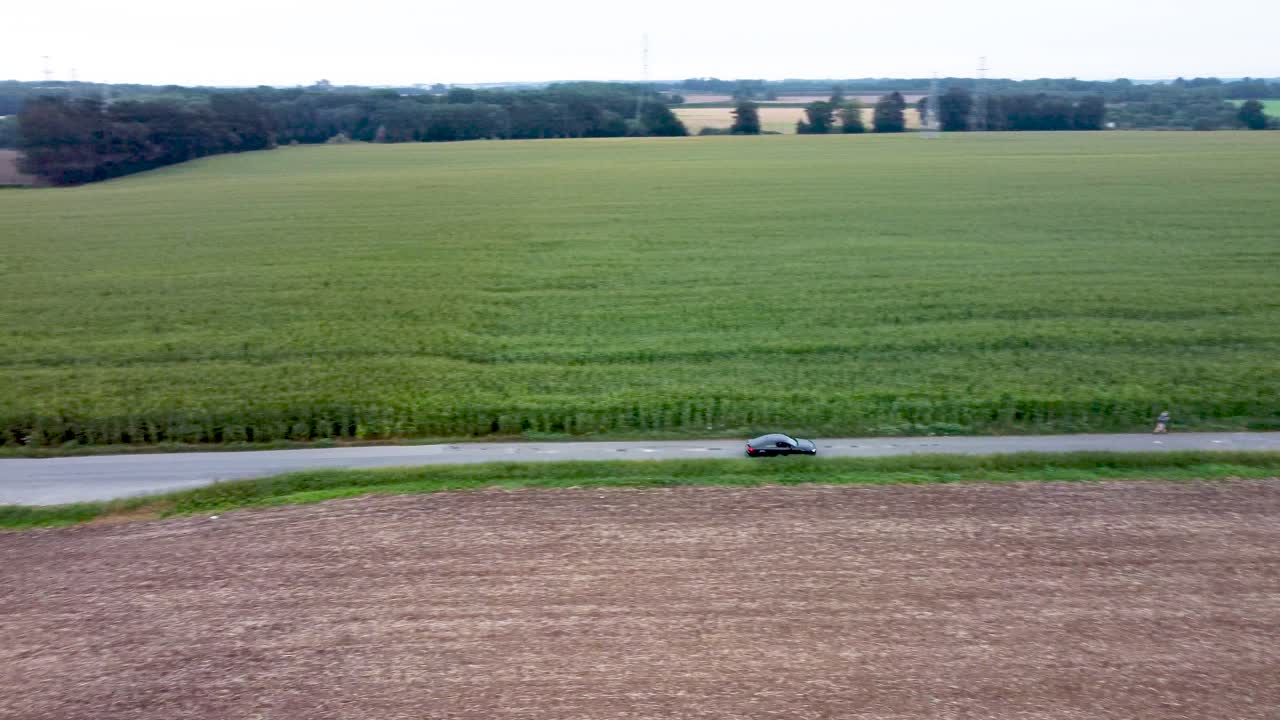 coche pasando por la carretera a2 pasar campos agrícolas en el sur de canterbury