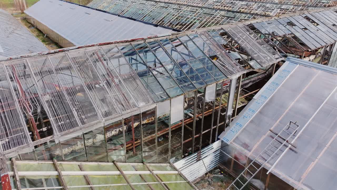 Drone moves past shattered greenhouse frames in diagonal spring movement