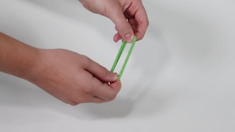 hands pulling and stretching a green hair tie