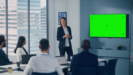 presentación de reuniones en la sala de conferencias de la oficina: joven mujer de negocios caucásica motivada habla, utiliza pantalla verde chroma key wall tv. presentación exitosa de un producto a un grupo de inversores multiétnicos
