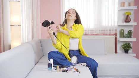 young woman blow drying her hair.