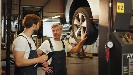 auto mechanics inspecting a tire