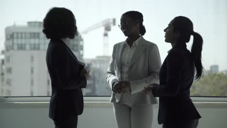 mujeres de negocios alegres hablando en la oficina.