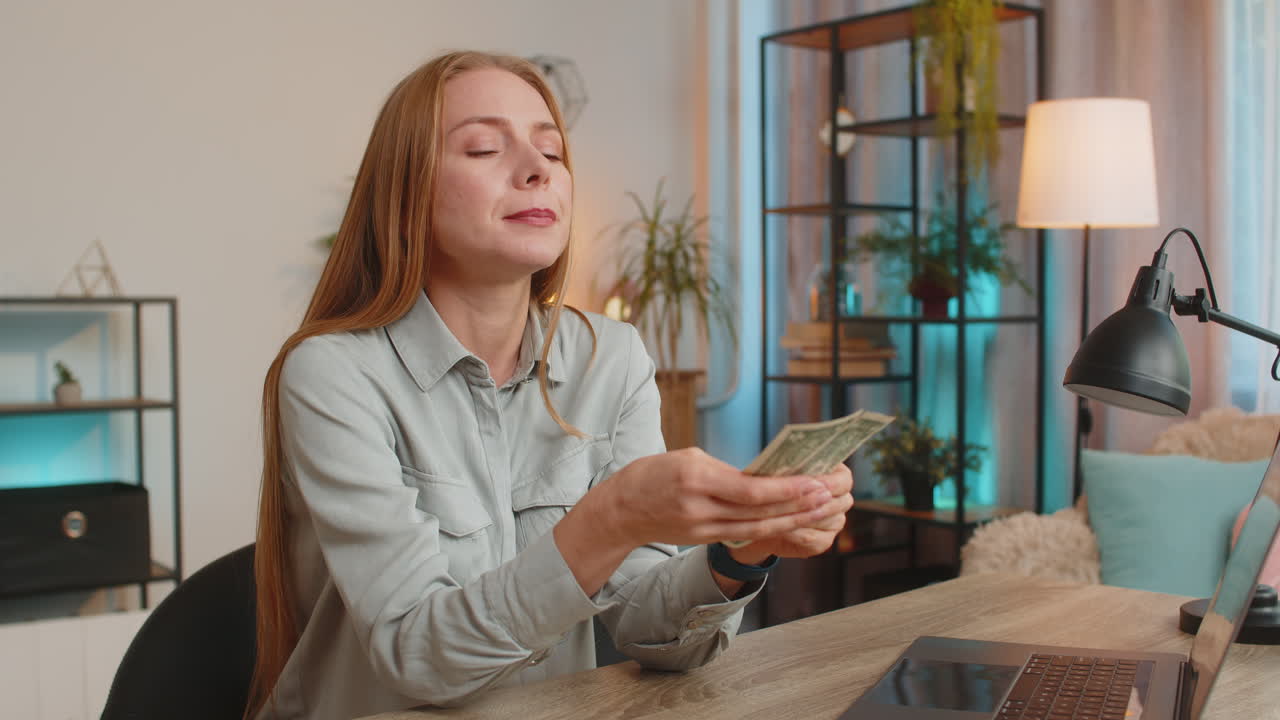 Upset caucasian woman freelancer counting dollar cash insufficient amount of money sitting at table