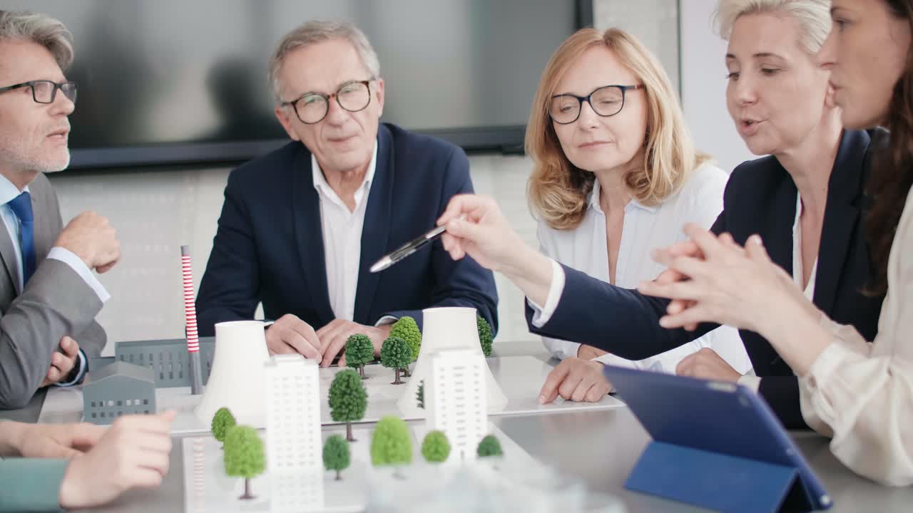 직장 동료 들 이 사무실 에서 새로운 프로젝트 에 대해 이야기 하고 있다