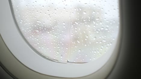 gota de lluvia en la superficie de la ventana del avión desde el interior de la cabina