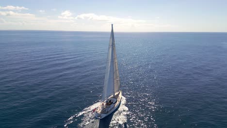 Aerial-orbiting-around-Oyster-82-sailboat-navigating-on-blue-ocean-waters