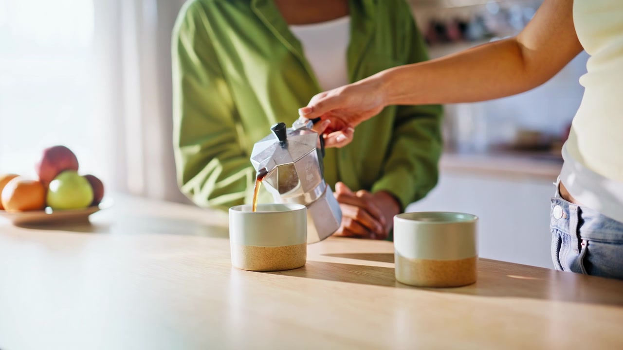 Donne che versano caffè fresco dalla moka in cucina. Amiche che preparano il caffè a casa.