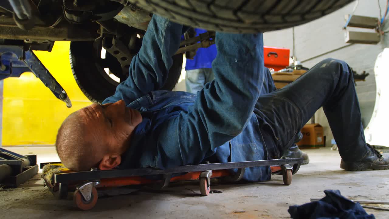 mecánico examinando un coche 4k