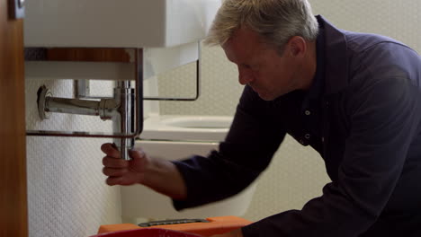 plumber working on sink in bathroom shot on r3d