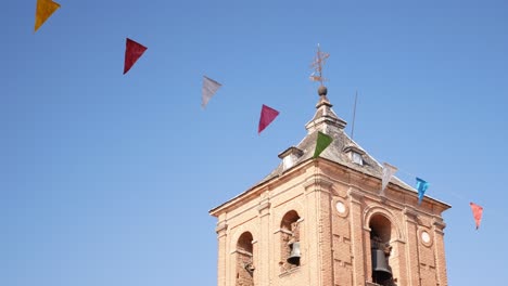 slowly panning from festival flags to the bell tower of saint john baptist church in ávila, spain