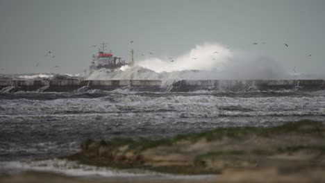 wild coastal storm waves batter ijmuiden lighthouse and pier with ship in back