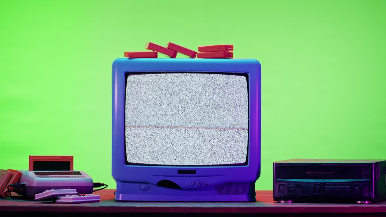 viejo televisor con pantalla de interferencia gris sobre fondo de neón púrpura. primer plano de televisión vintage y cartuchos para playstation retro. videojuego antiguo, nostalgia