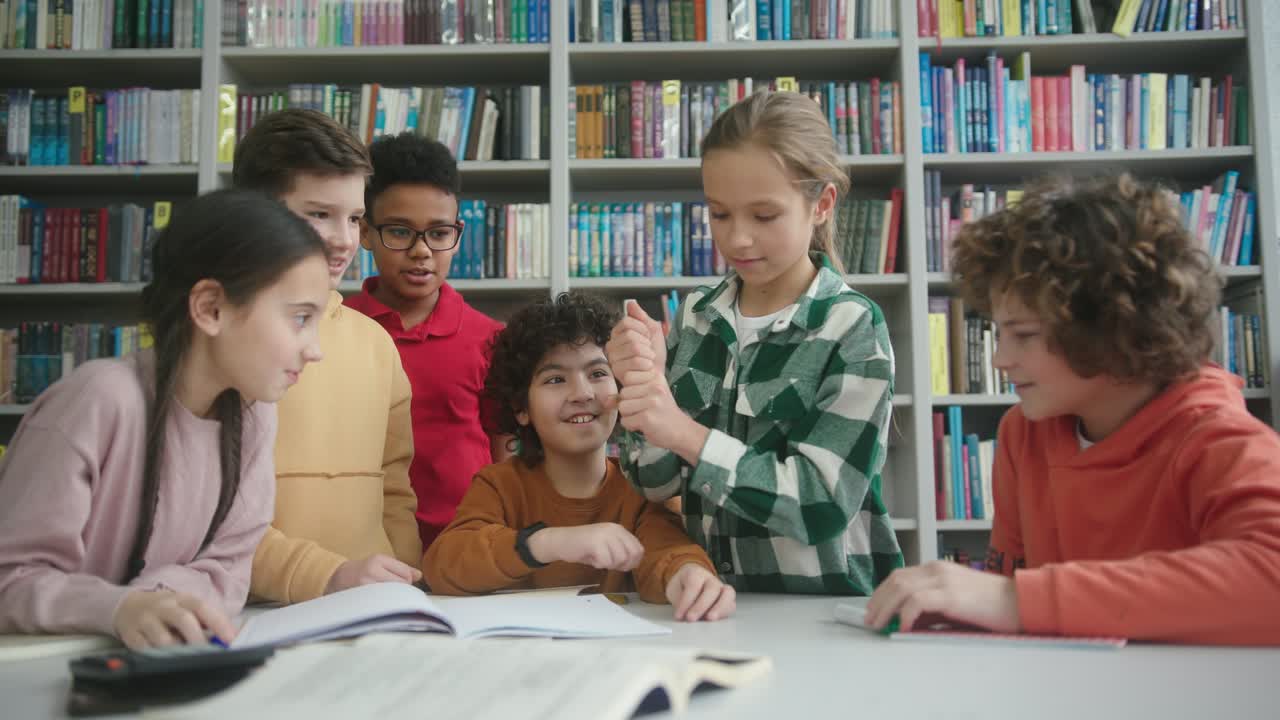 다국적 아이들은 도서관에서 한 머리카락을 가진 소년을 둘러싸고 있습니다.