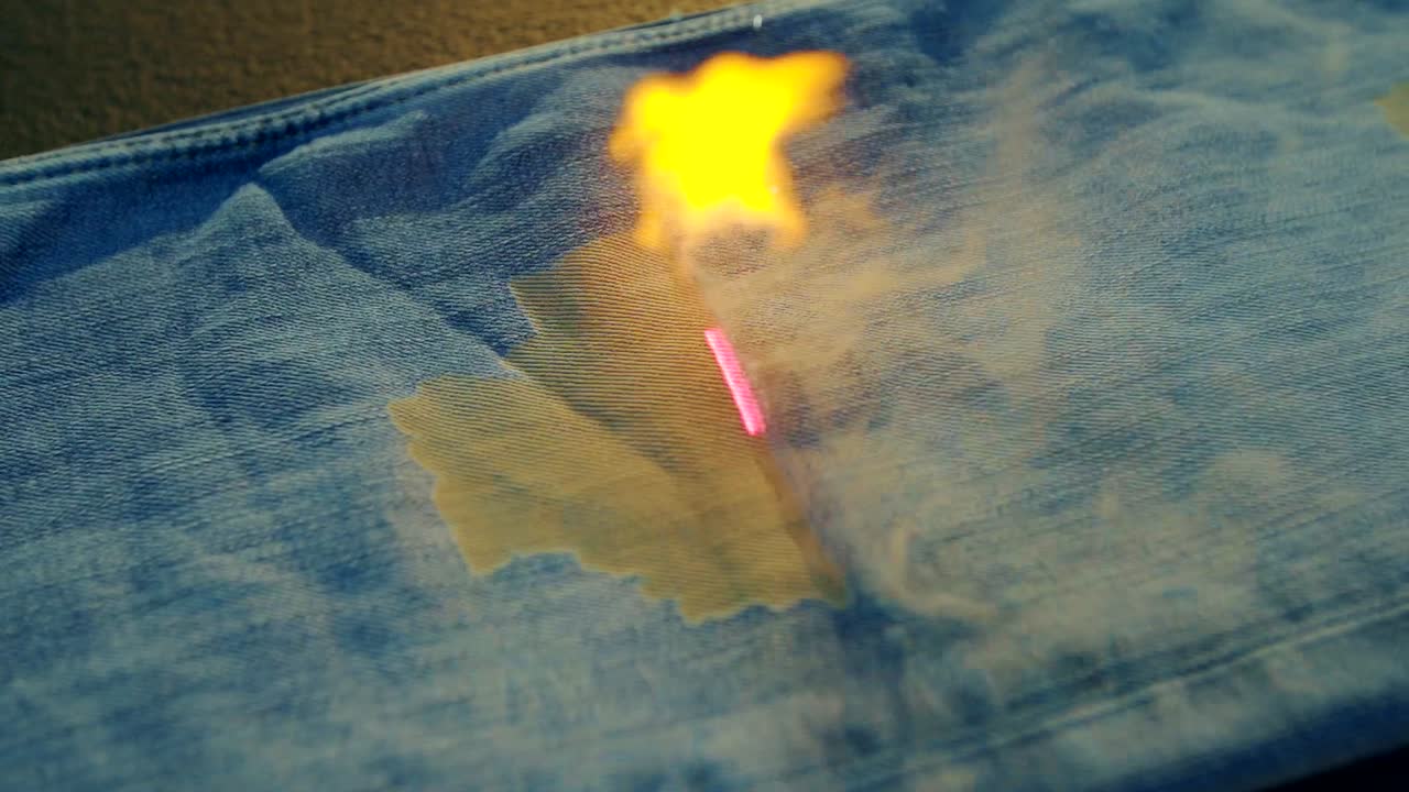 denim factory using laser beams to make design on blue jeans