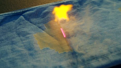 denim factory using laser beams to make design on blue jeans