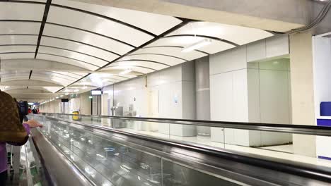 passengers on a moving walkway at suvarnabhumi airport