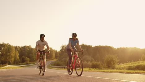 Hard-Training.Triathlete-two-Cyclist-Training-On-Road-Bicycle.-two-Cyclist-Riding-On-Road-Bike-In-City-Park-And-Getting-Ready-For-Triathlon.Fit-Athlete-Intensive-Training-two-man-and-woman-Cycling-Before-Triathlon-Competition.