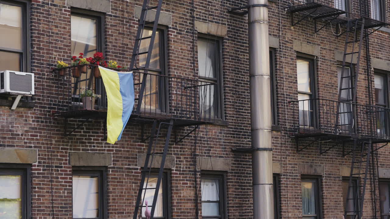 La bandiera ucraina sventola al vento per solidarietà su una casa a Manhattan, ripresa statica.