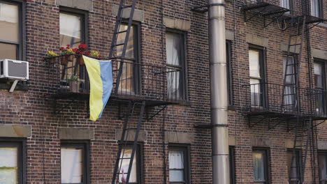 la bandera ucraniana ondeando en el viento por la solidaridad en una casa en manhattan, tiro estático