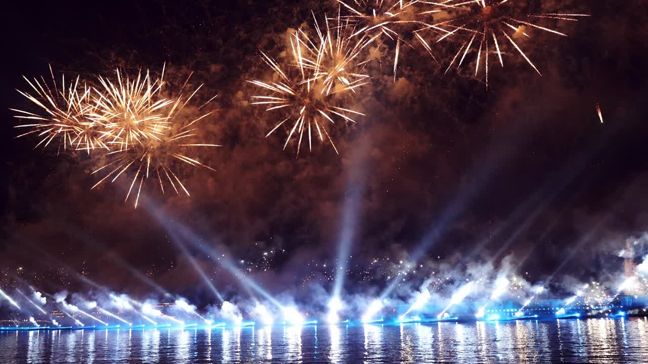 fuegos artificiales coloridos festivos e iluminación en el cielo oscuro con un hermoso reflejo en el agua. velas escarlata de vacaciones