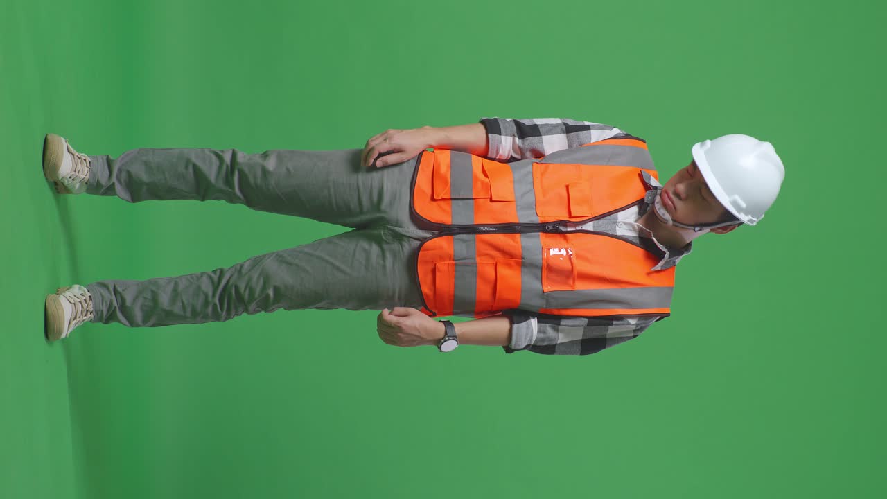 Full Body Of Asian Male Engineer With Safety Helmet Having A Headache While Working In The Green Screen Background Studio