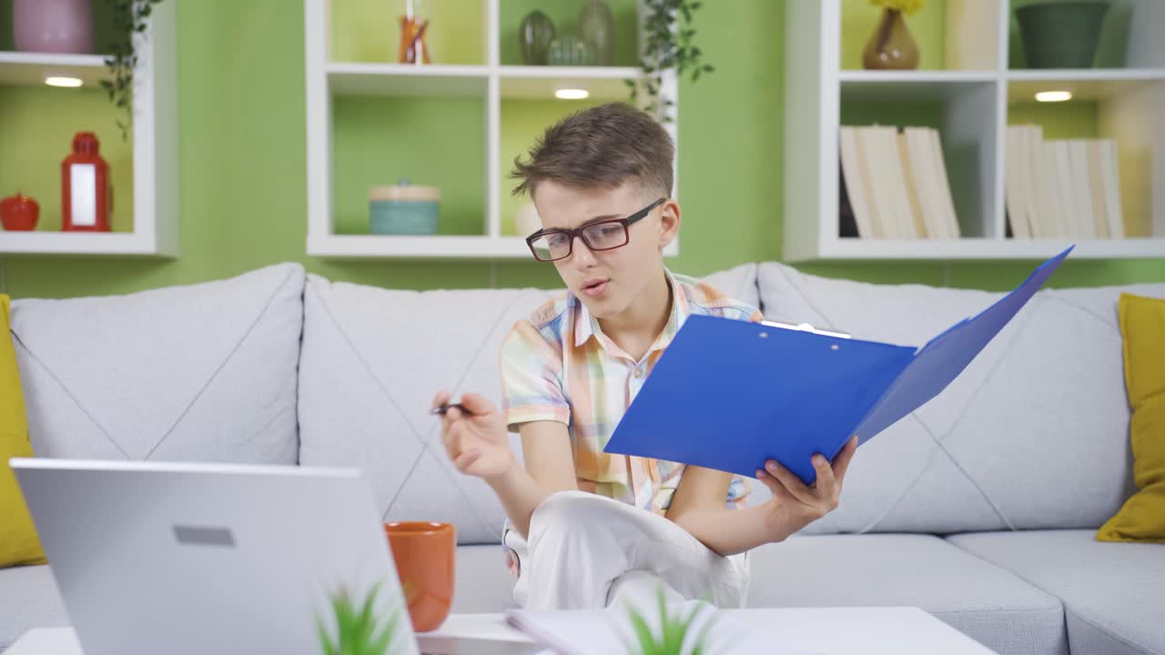 Little boy working on his father's laptop and file. He dreams of becoming a businessman.