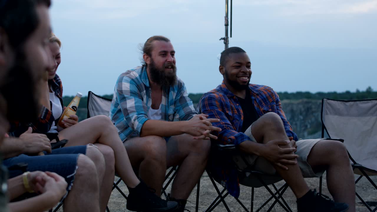 Laughing diverse friends playing charades in camp