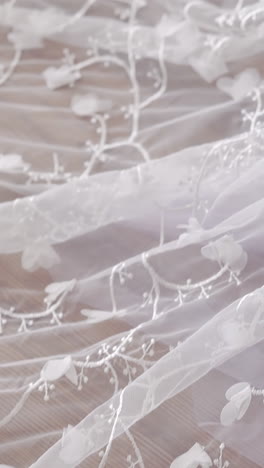 slow motion close view white long transparent train with patterns near purple rose bouquet in lady hand