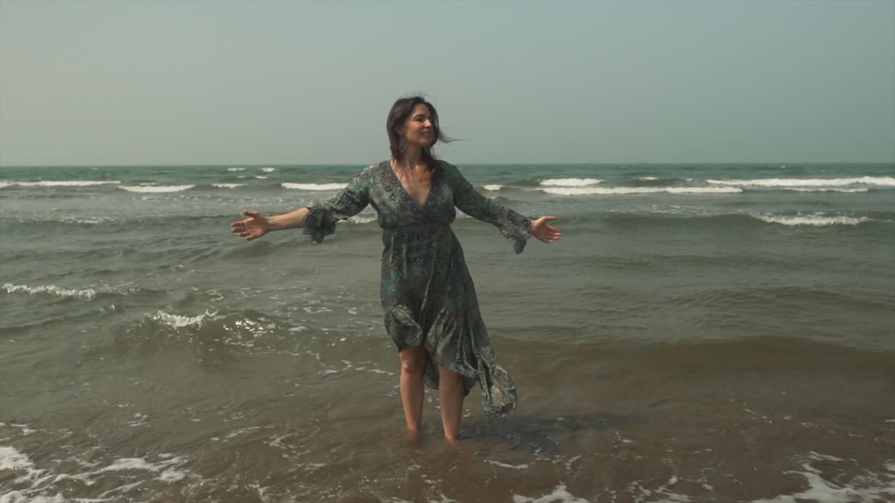 una mujer bonita vestida de verde abraza alegremente la playa soleada y el paisaje tropical en el fondo, con un amplio espacio para copiar