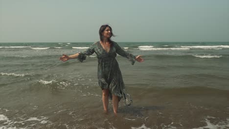 pretty woman in green dress joyfully embraces the sunny beach and tropical landscape in the background, with ample copy space